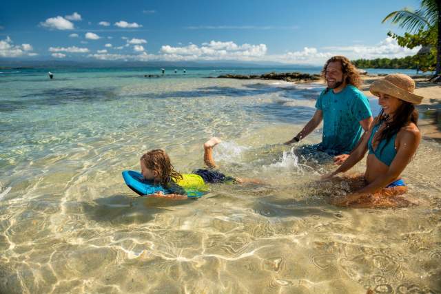 Family enjoying at the cristal waters of Boca del Drago beach
