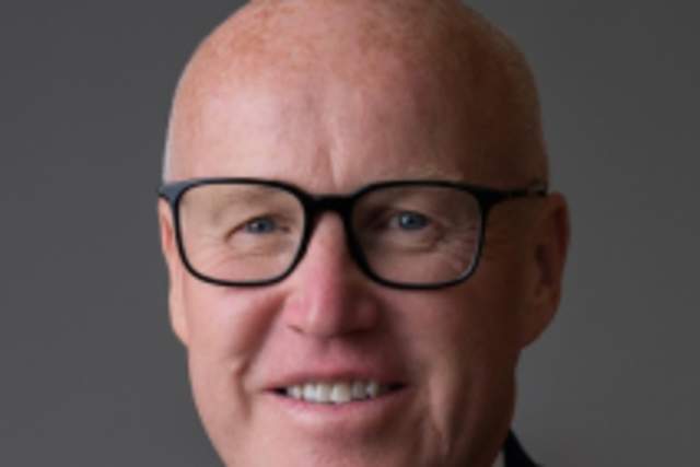 Smiling  man in dark blue suit and matching tie