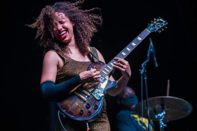 Femal guitarist Jackie Venson plays the guitar on stage at Love and Lightstream event in Austin Texas