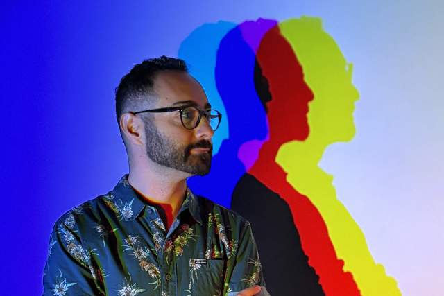 Standing man with multi-color light reflection