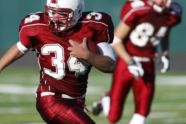 young man running with the ball during a football game
