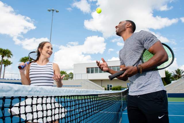 A couple playing tennis at the USTA facilities near the Lake Nona Wave Hotel