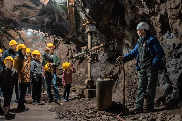 A group of people takes an underground copper mine tour at Quincy Mine.