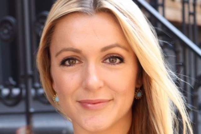 Half smiling woman standing in front of stairs