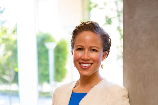 Woman standing next to a pillar smiling