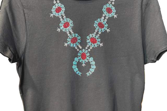 A black T-shirt featuring a decorative floral necklace design made of colorful southwestern elements