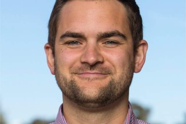 Smiling man in pink button up shirt