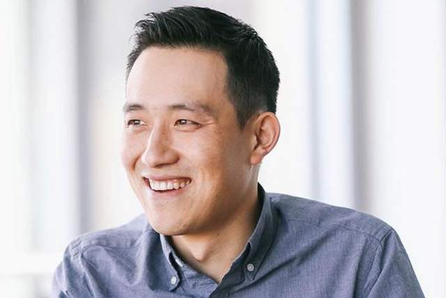 Smiling man looking off camera in a blue button down shirt