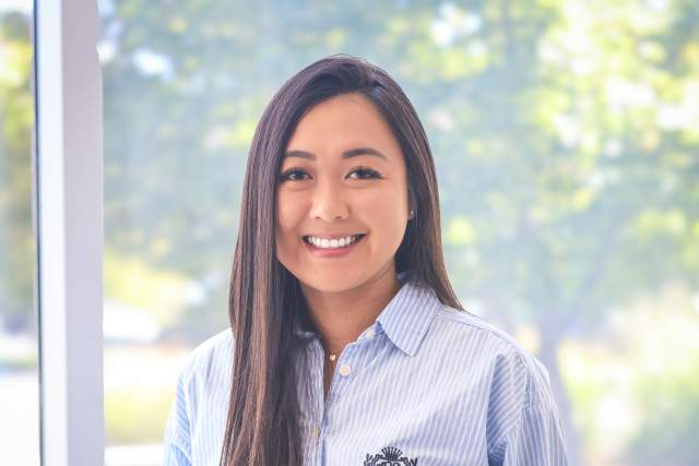 Smiling nwoman wearing light blue button down shirt