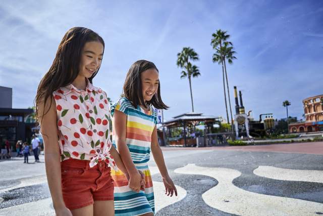 Two girls walking across a splash pad at Universal Citywalk Orlando
