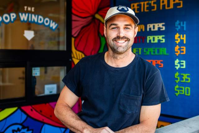 Pete Cooney of Pete's Pops leaning against a serving counter and smiling