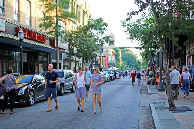 group of people walking downtown Dauphin Street