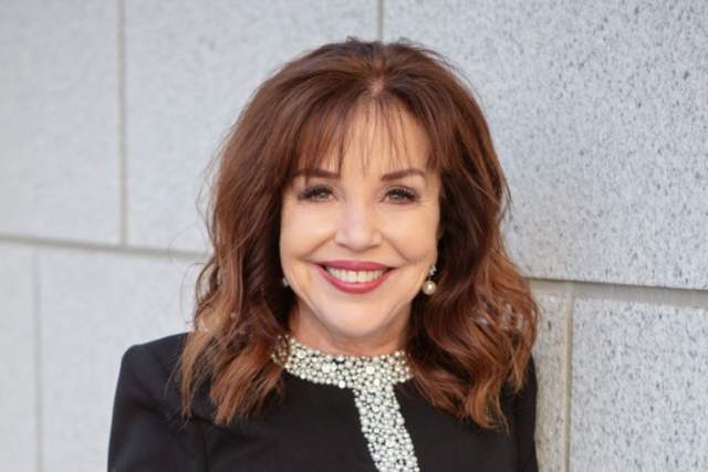 Smiling woman in black dress with silver accents