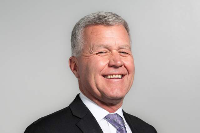 Smiling photo of Jim Olson wearing a suit
