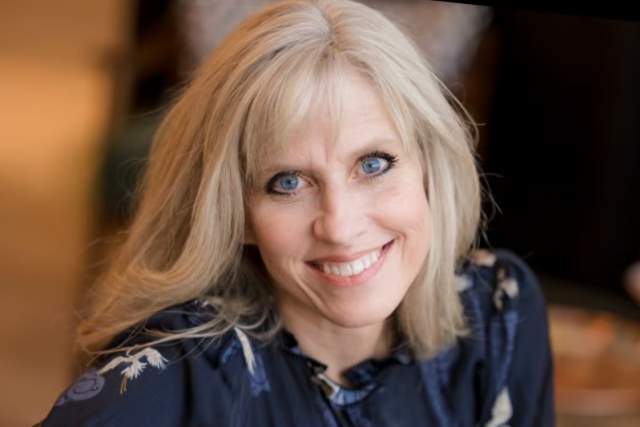 Smiling woman in dark blue flower dress shirt