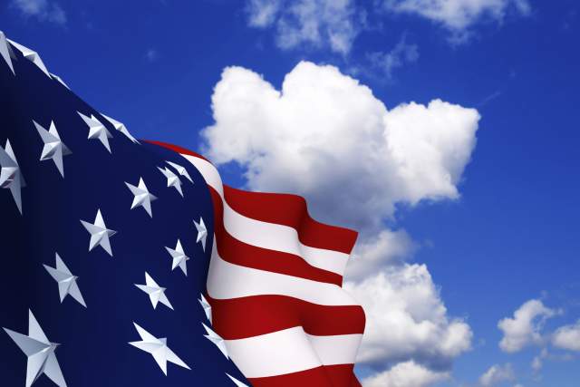 Closeup of an American flag with a blue sky background