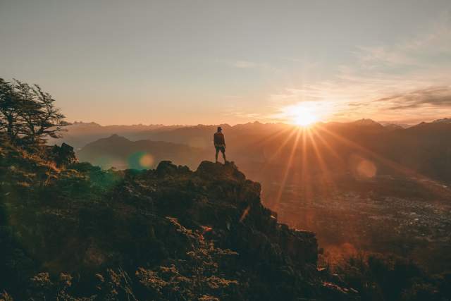 Man standing on top of mountain looking into valley