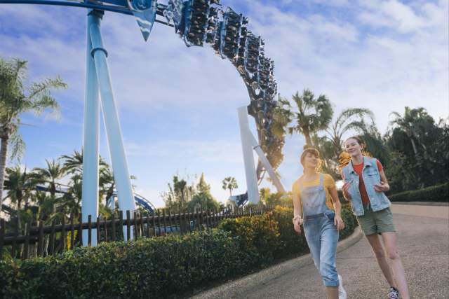 Girls walking past the Manta Rollercoaster at SeaWorld Orlando