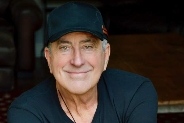 Smiling man in a dark blue ball cap and t-shirt
