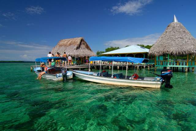 Tourists on the dock of Isla Bastimentos boarding boats in the crystal-clear waters of the Isla Bastimentos Marine National Park in Bocas del Toro.