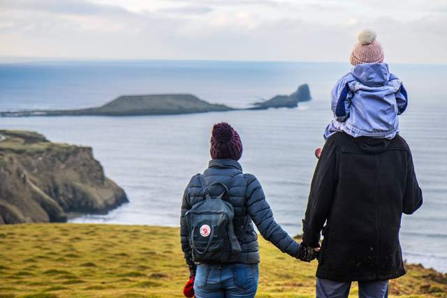 A man and a woman looking out at Worm's head. The man has a child on his shoulder.