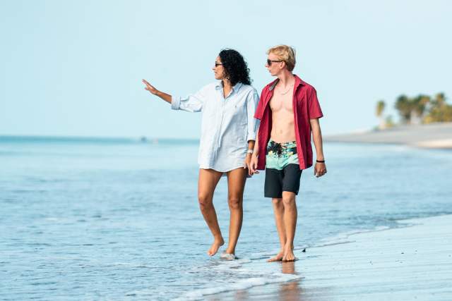 Friends leisurely walk along the sandy beach of Buenaventura