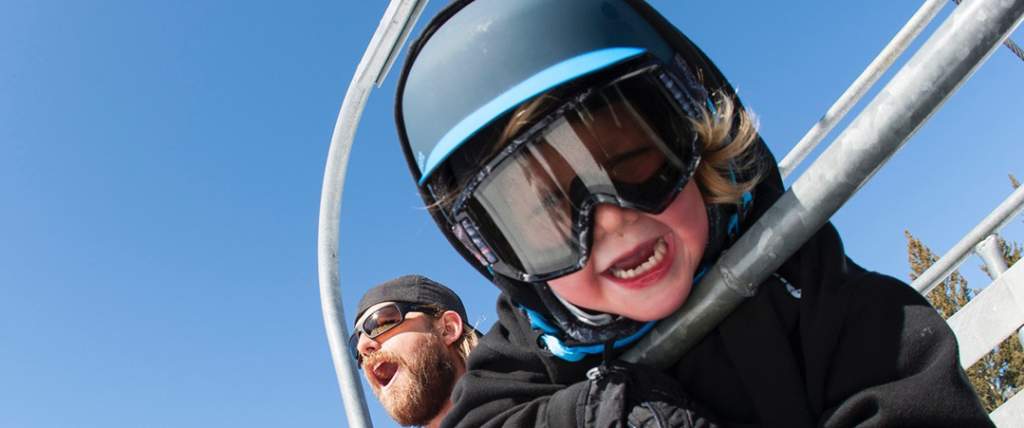 Dad and son on ski chairlift at Brighton