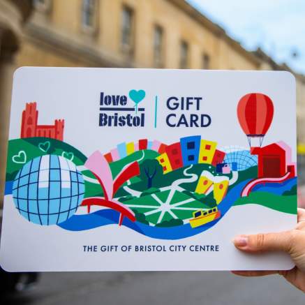 Hand holding a Love Bristol Gift Card shopping voucher in Park Street, central Bristol - credit Bristol BIDs