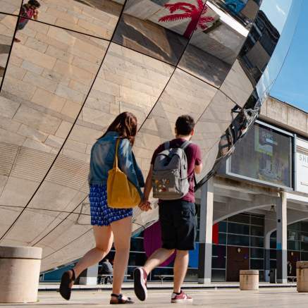 Couple walking in Millennium Square on Bristol's Harbourside - credit Visit West