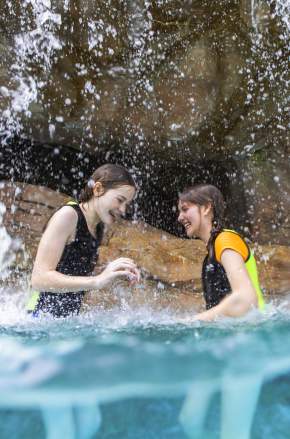 Two girls playing in a waterfall at Discovery Cove