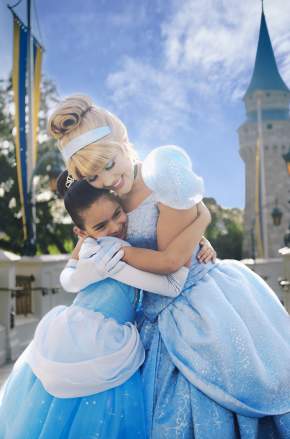A girl, in a costume, and Cinderella hugging at the Magic Kingdom in the Walt Disney World Resort.