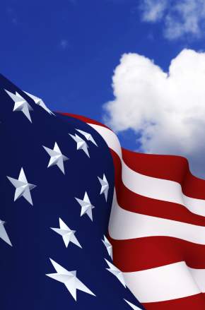 Closeup of an American flag with a blue sky background