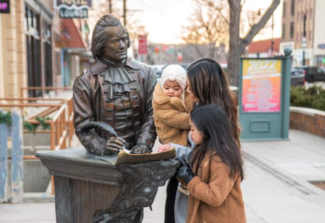 family all looking at the thomas jefferson statue in the city of presidents walking tour in downtown rapid city, sd