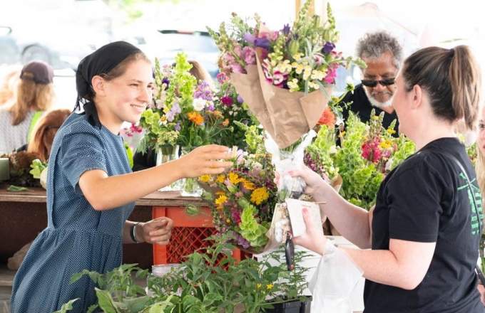 Flower Sale between two women at a vendor booth at the Lewisburg Farmers Market