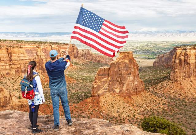 People Posing with American Flag on Colorado National Monument
