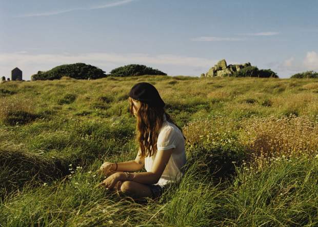 Girl sitting on grass in Autumn
