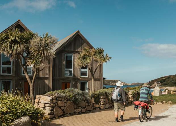Couple walking past cottages on Tresco