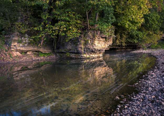 A tree-lined bluff overlooking a body of water.