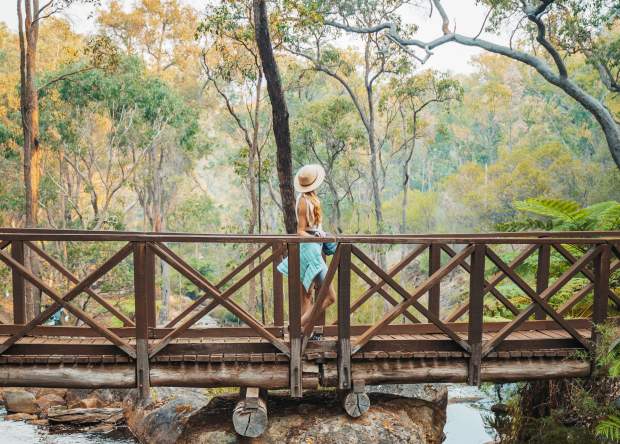 Girls walks across a bridge at Araluen Botanic Park in Armadale