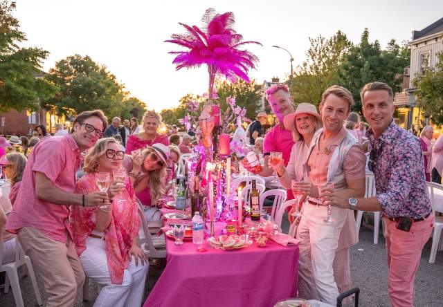 Group of people dressed in pink attending a pink-themed street party