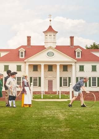 A family plays colonial games with interpreters at The American Village in Montevallo.