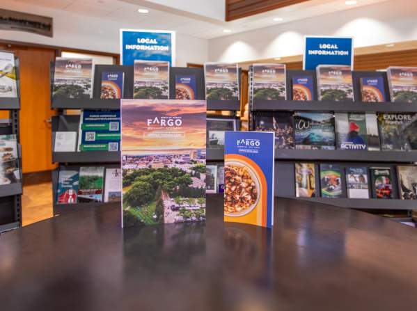 Fargo visitor guide and dining guide in front of brochure racks