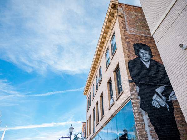 black mural of singer bob dylan on a brick building