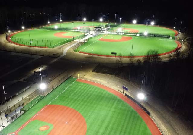 5 diamond fields at night with field lights on showcasing the baseball/softball setups