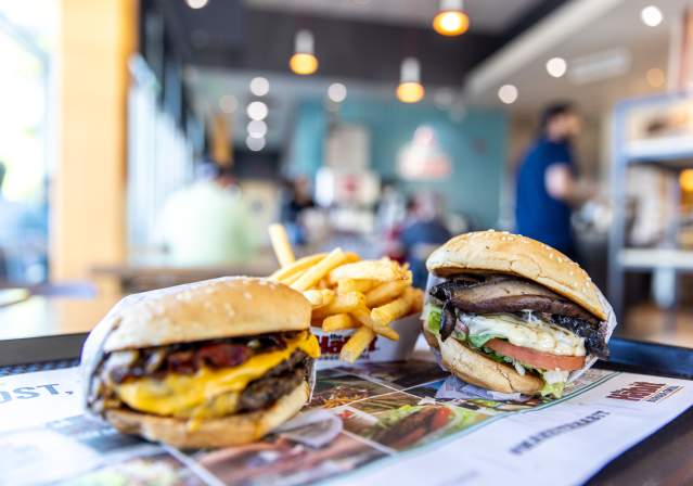 Two burgers with fries on a tray.
