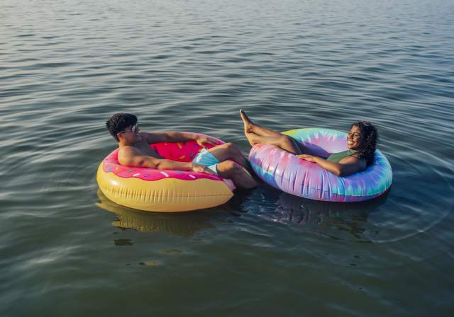 Couple floating in tubes on the water