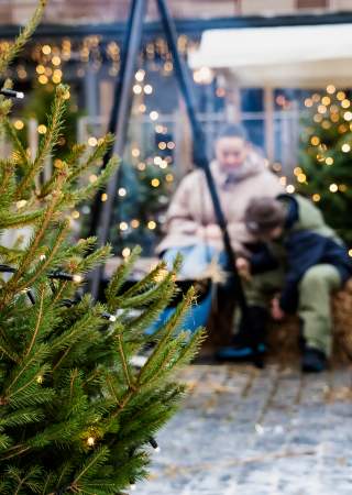 Mor og barn foran bålpanne på Brumunddal torg.