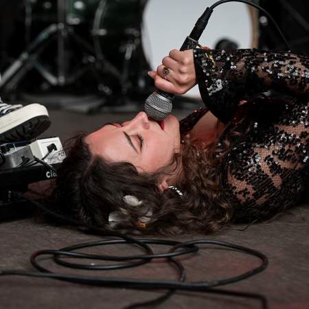 A woman lying on the ground singing into a microphone