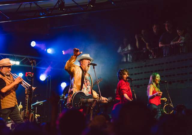 Image of a band onstage at Mohawk with the main man holding his hand up and singing into the microphone.