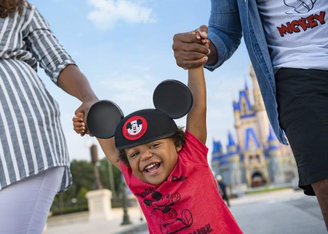 Child holding family's hand at Magic Kingdom